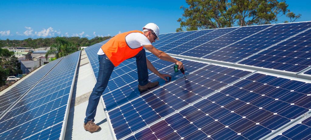Worker inspects solar panels in a large installation